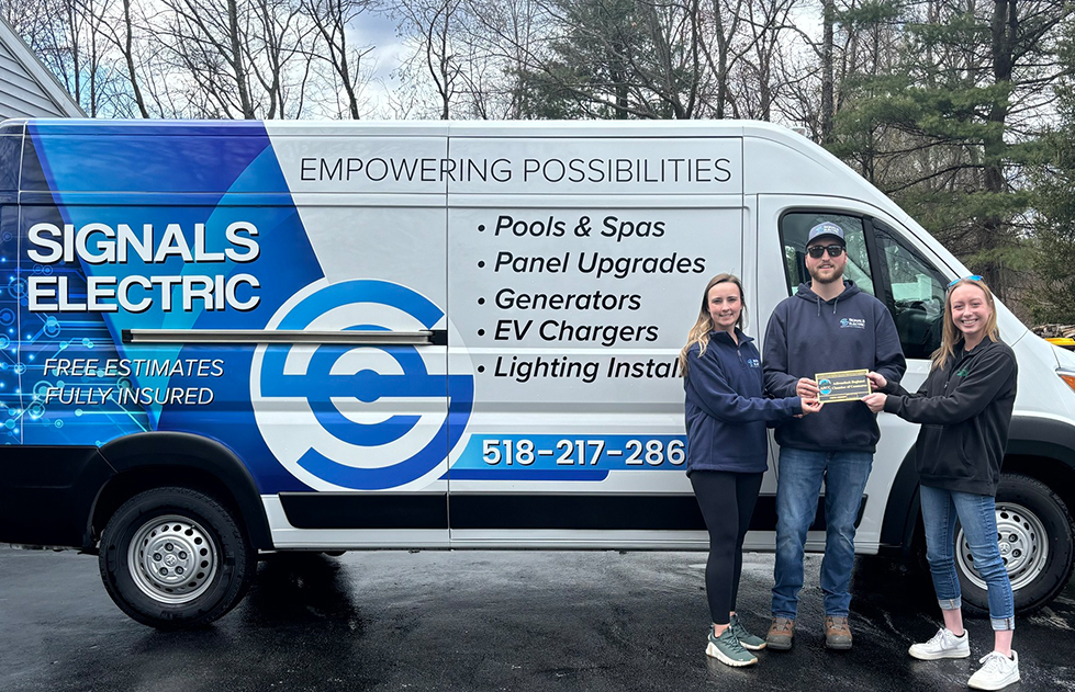 signals electric showing off ARCC badge in front of company vehicle